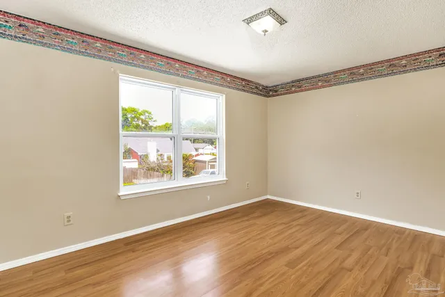 a view of backyard with wooden fence and a large tree