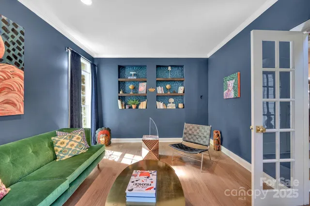 a bedroom with a bed flat screen tv and chairs