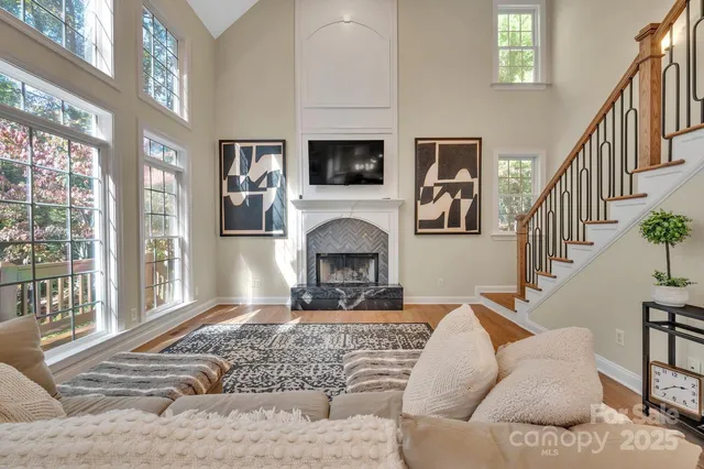a living room with furniture a flat screen tv and a fireplace