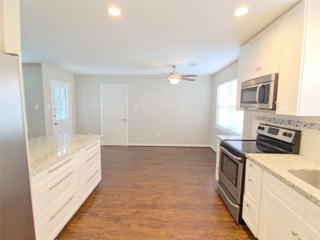 a large kitchen with a stove top oven and cabinets