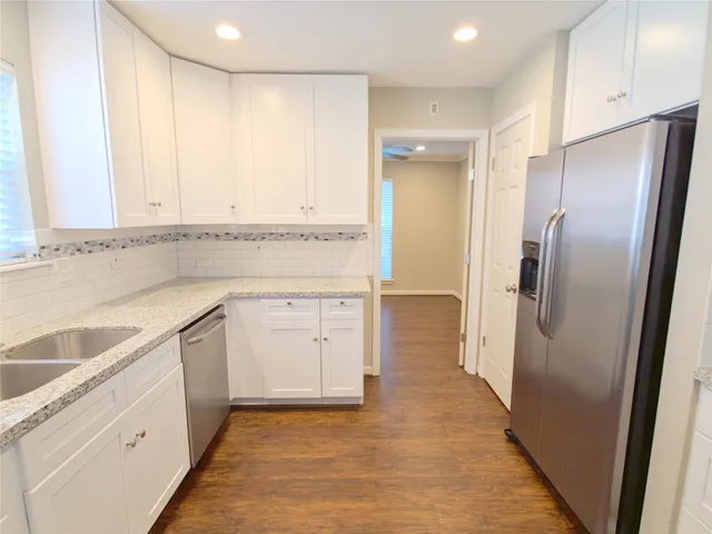a view of a kitchen with white cabinets