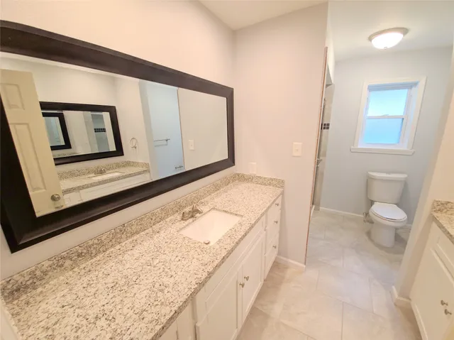 a bathroom with a granite countertop sink and a mirror