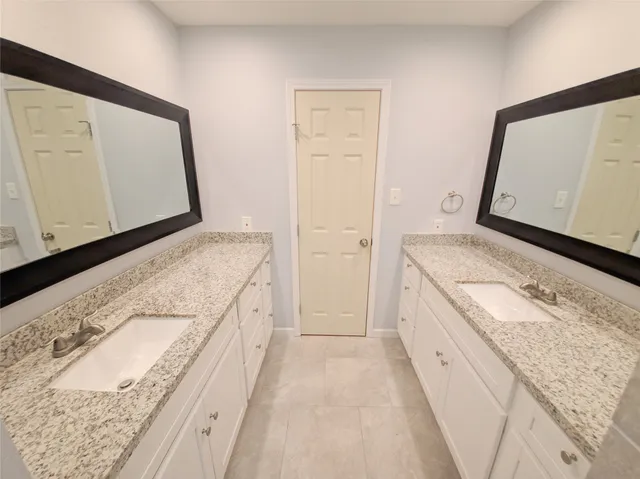 a spacious bathroom with a granite countertop sink and a mirror