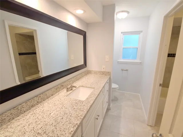 a bathroom with a granite countertop sink and a mirror