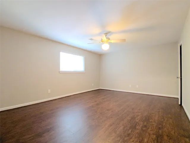 an empty room with wooden floor and window