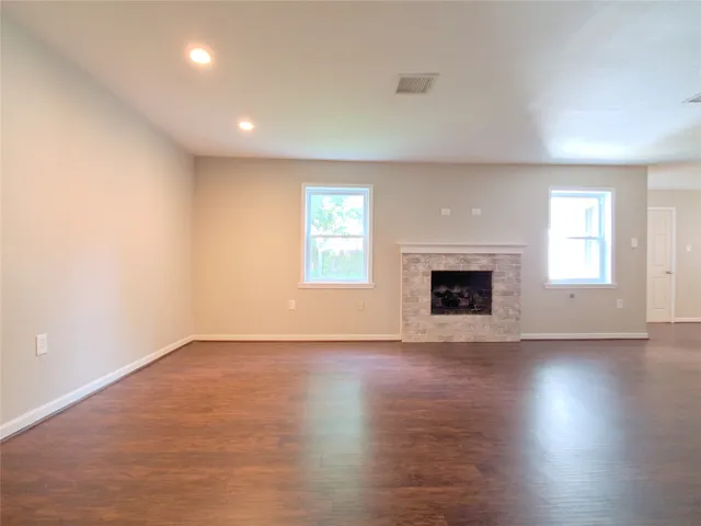 an empty room with wooden floor and fireplace