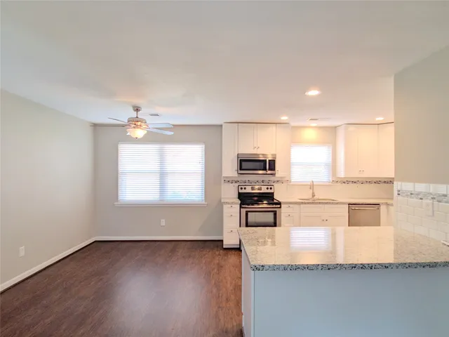 a kitchen with stainless steel appliances granite countertop a stove a sink and a microwave