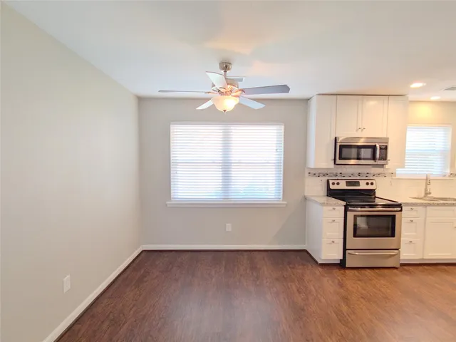 a kitchen with granite countertop a stove a sink and a microwave