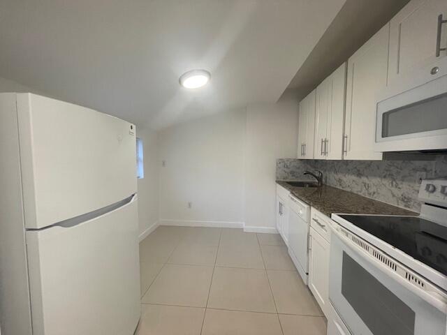 919 2nd Street, Unit 3 West Palm Beach, FL 33401 - Photo 2 of 11 a kitchen with a sink and a refrigerator