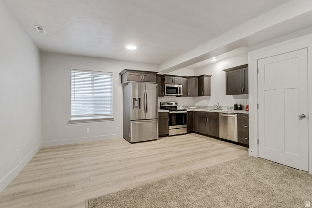 4572 Flower Point Eagle Mountain, UT 84005 - Photo 50 of 62 Kitchenette featuring stainless steel appliances, dark wood-finish cabinetry, and light-toned countertops