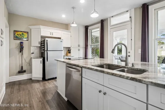 a kitchen with granite countertop a refrigerator and a sink