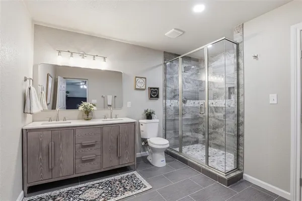a bathroom with a double vanity sink mirror and toilet