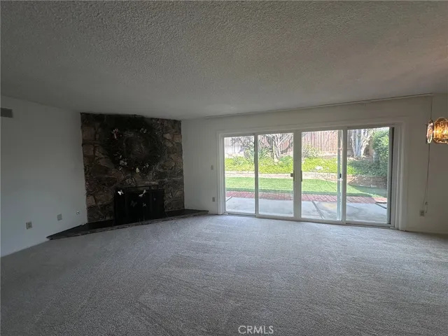 a view of an empty room with glass door and a window