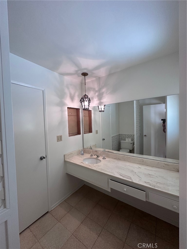 20631 Romar Street Chatsworth, CA 91311 - Photo 15 of 34 a en suite bathroom with a granite countertop sink and a mirror