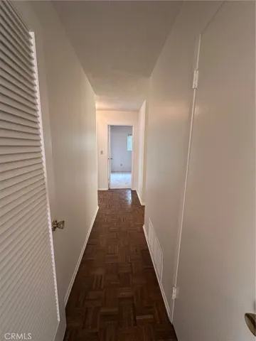 a walk in closet with wooden floor