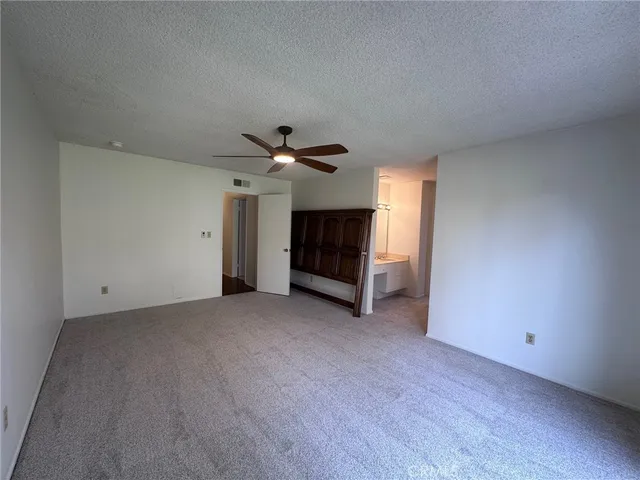 a view of empty room with a ceiling fan and window
