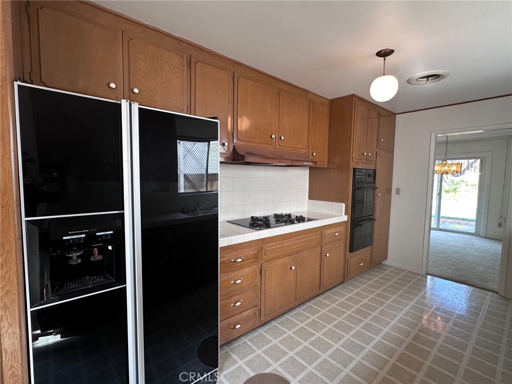 20631 Romar Street Chatsworth, CA 91311 - Photo 6 of 34 a kitchen with granite countertop a refrigerator and a sink