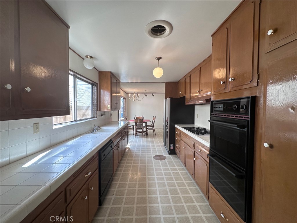 20631 Romar Street Chatsworth, CA 91311 - Photo 8 of 34 a large kitchen with stainless steel appliances a large counter top a stove a sink and a refrigerator