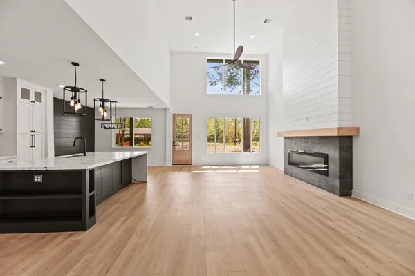 a large kitchen with kitchen island a sink dishwasher a stove and a dining table with wooden floor