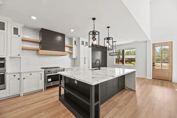 a large kitchen with kitchen island a sink stainless steel appliances and cabinets