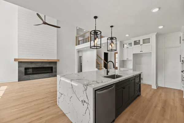 a kitchen with stainless steel appliances granite countertop a sink cabinets and wooden floor