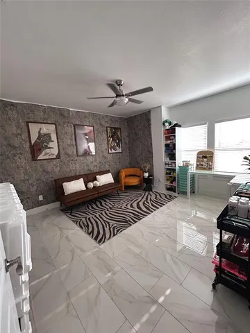 a living room with furniture a ceiling fan and a rug