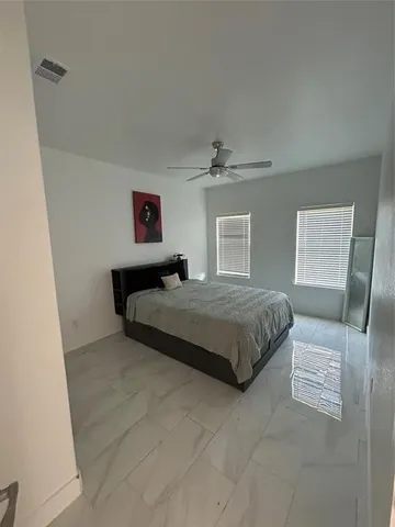 a bedroom with a large bed and a lamp