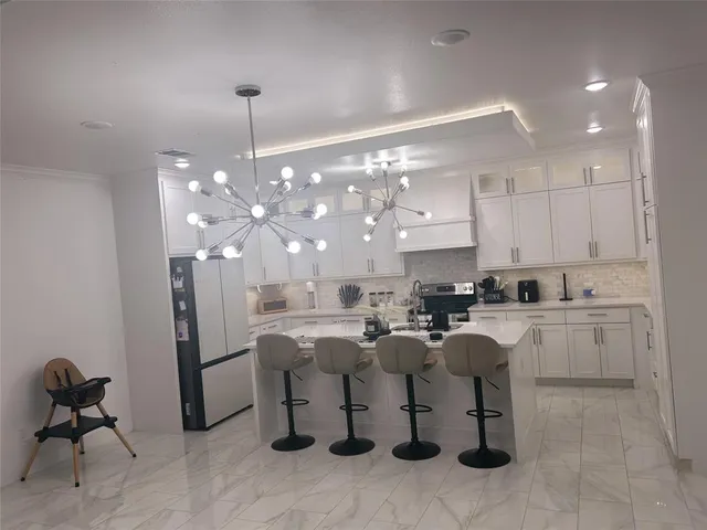 a kitchen with cabinets and chairs
