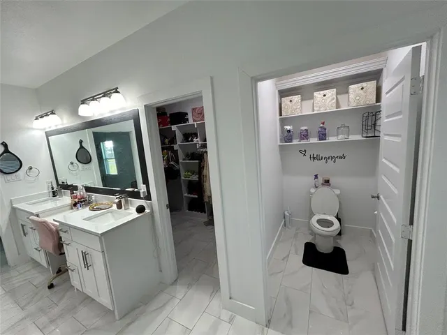 a bathroom with a sink a toilet and a mirror
