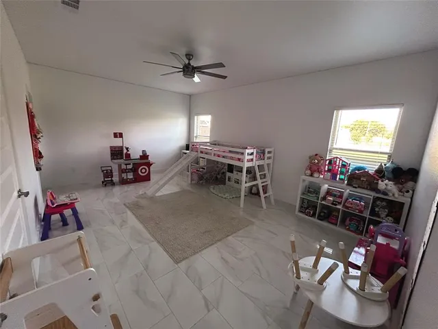 a living room with furniture and a flat screen tv with kitchen view