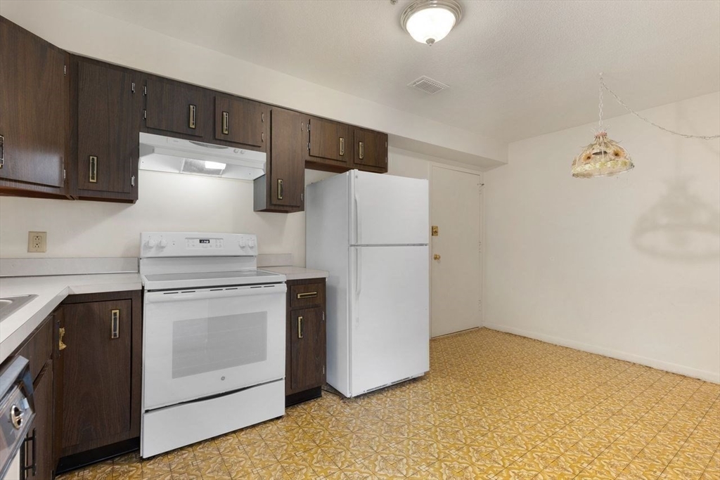 1008 Paradise Road, Unit 2Q Swampscott, MA 01907 - Photo 14 of 25 a kitchen with a refrigerator sink stove and cabinets