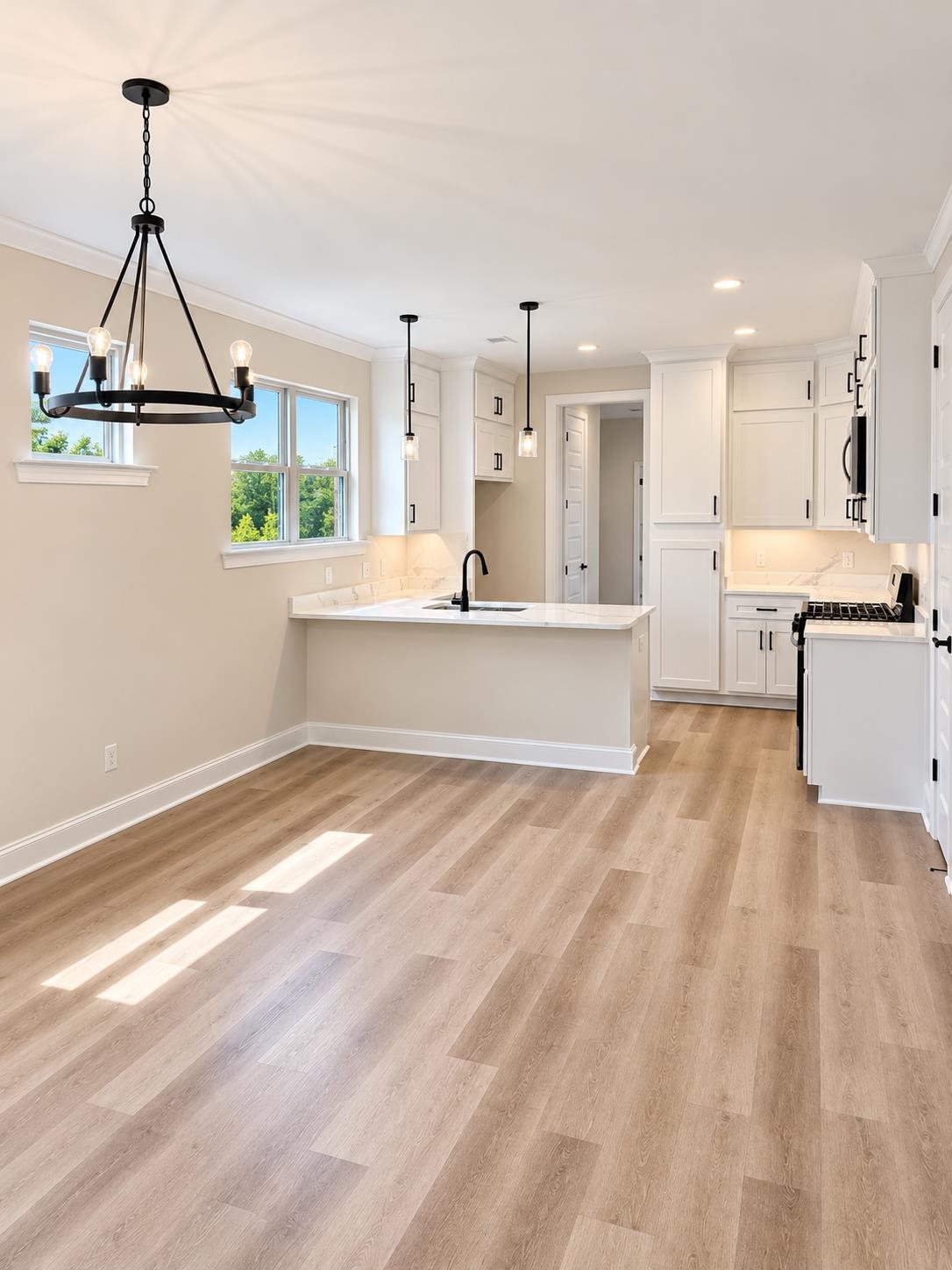 5545 Shipp Road Millington, TN 38053 - Photo 5 of 12 Open-concept kitchen and dining area featuring wood-finish flooring, white cabinetry, recessed lighting, and a black chandelier