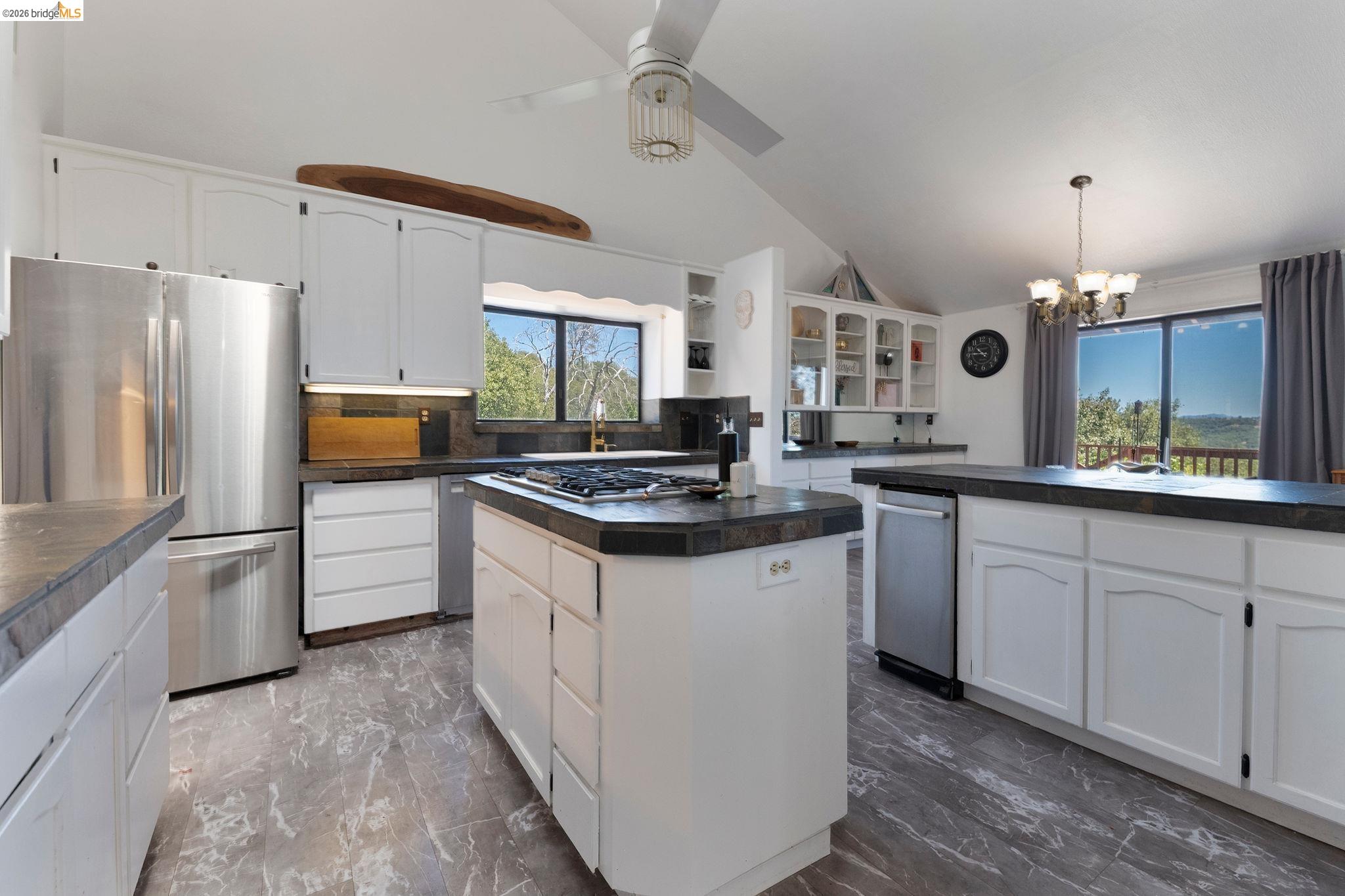 22963 Robertson Ranch Road Sonora, CA 95370 - Photo 17 of 90 Spacious kitchen featuring white cabinetry, stone-finish countertops, stainless steel appliances, and wood-finish flooring