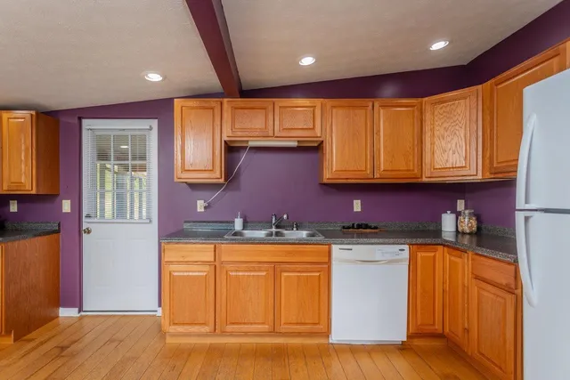 a kitchen with stainless steel appliances granite countertop a refrigerator a microwave oven a sink with island and chairs