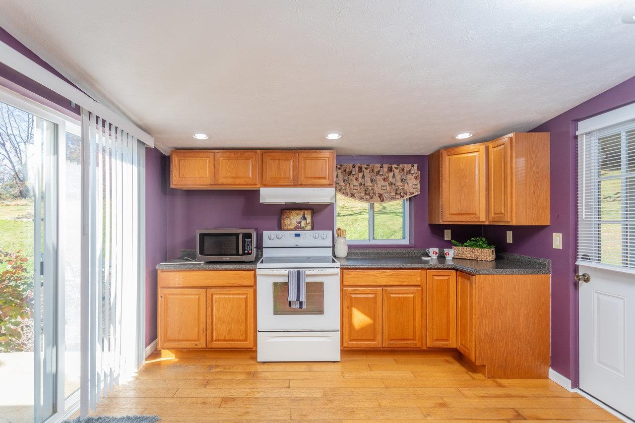 911 Old White Hill Road Stuarts Draft, VA 24477 - Photo 3 of 40 a kitchen with stainless steel appliances granite countertop a stove a sink and a microwave