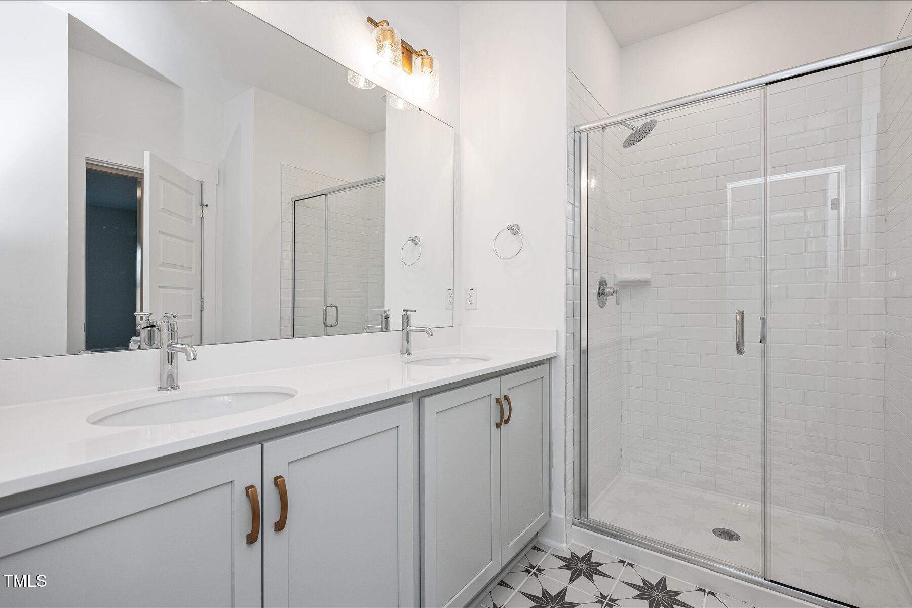 3939 Willow Gate Way Raleigh, NC 27604 - Photo 21 of 32 a bathroom with a shower sink vanity and mirror