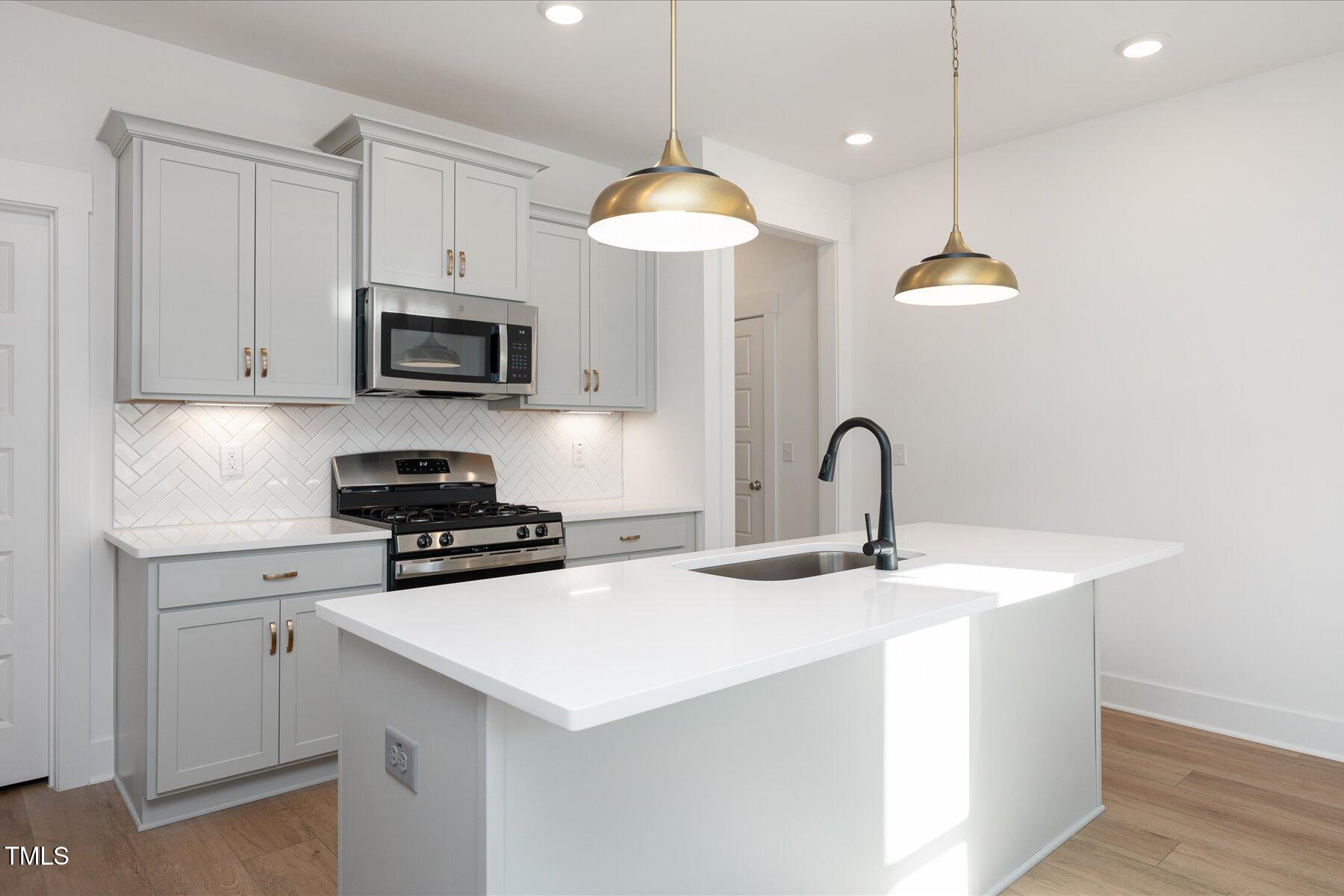 3939 Willow Gate Way Raleigh, NC 27604 - Photo 9 of 32 a kitchen with kitchen island a stove and a sink