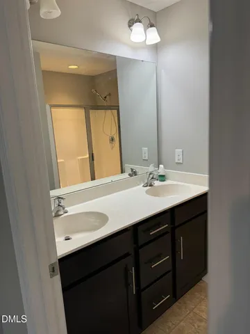 a bathroom with a sink double vanity and a mirror
