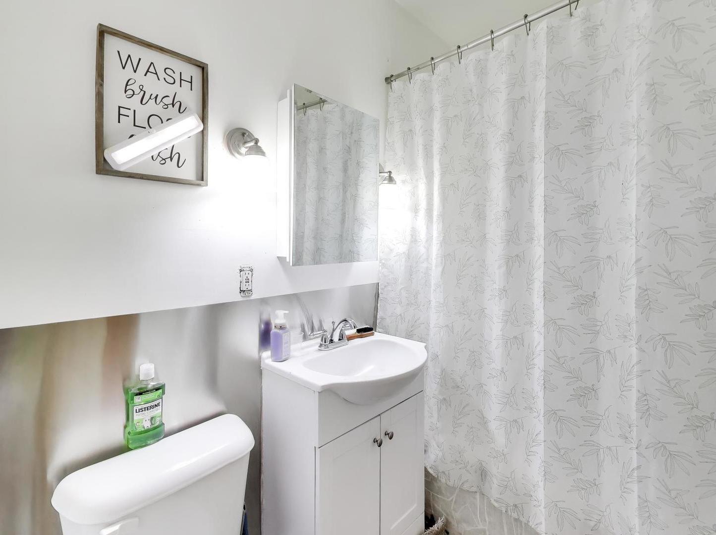 8322 South Sangamon Street Chicago, IL 60620 - Photo 17 of 36 a bathroom with a sink a toilet and a mirror