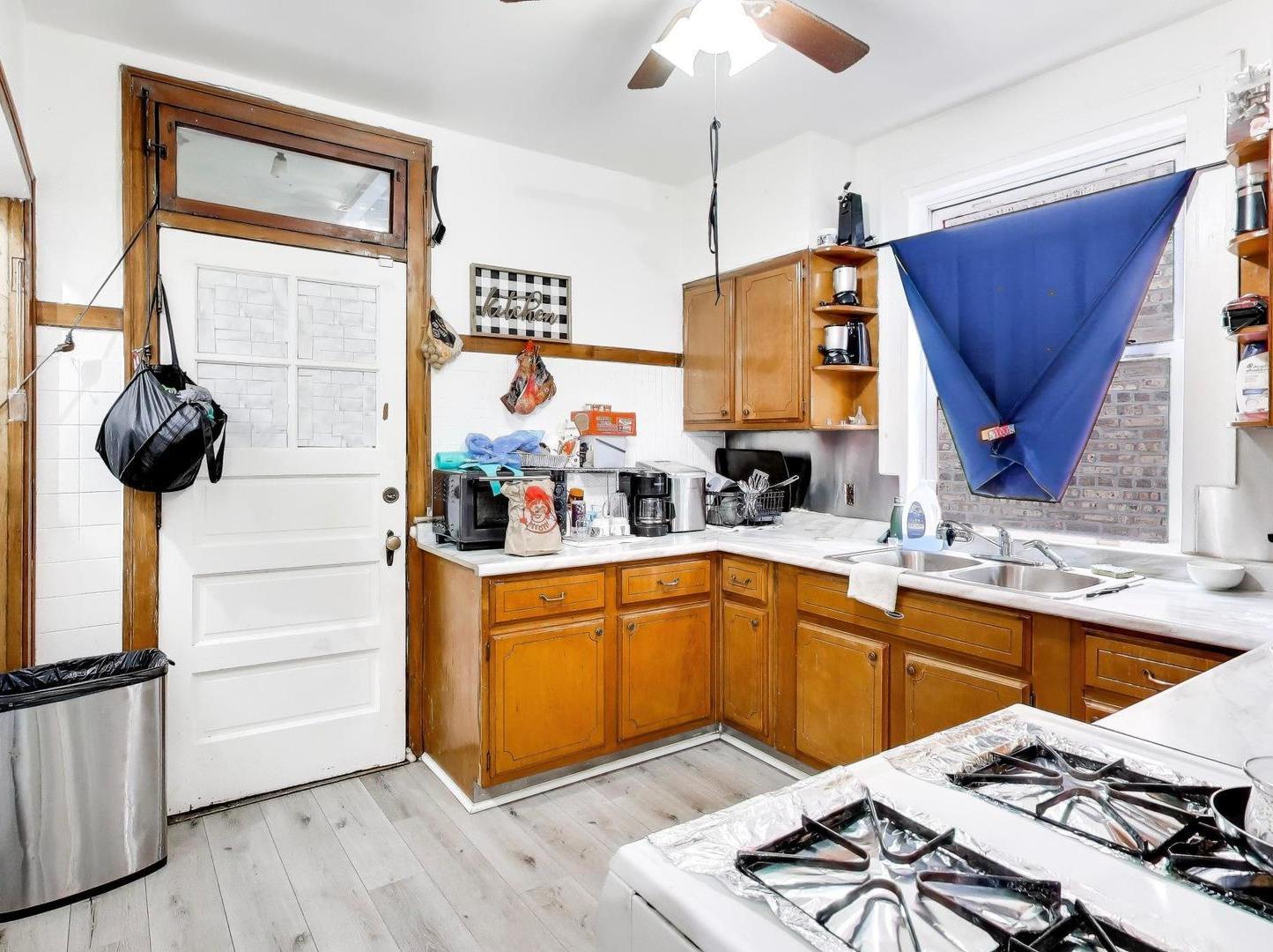 8322 South Sangamon Street Chicago, IL 60620 - Photo 18 of 36 a kitchen with stainless steel appliances granite countertop a sink a stove and a wooden floors