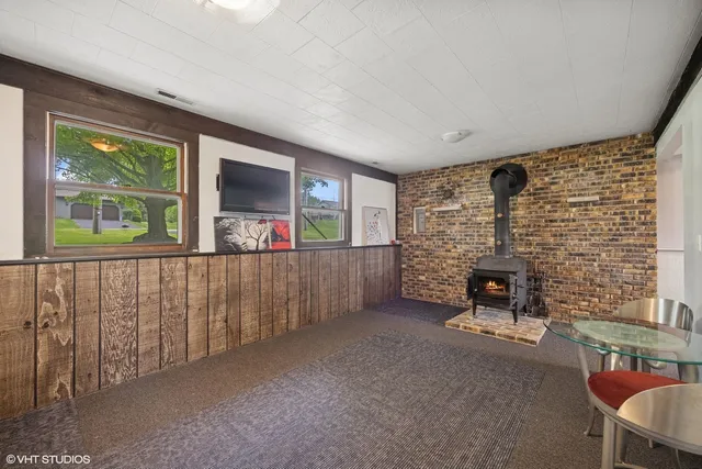 a living room with fireplace furniture and a large window