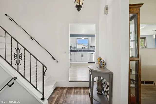 a view of a hallway with wooden floor and staircase