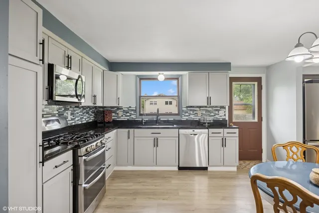 a kitchen with stainless steel appliances granite countertop a stove a sink and a refrigerator