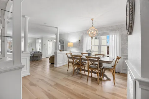 a view of a a dining room with furniture window and wooden floor