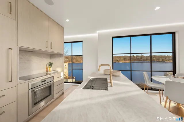 a kitchen with granite countertop a stove and white cabinets