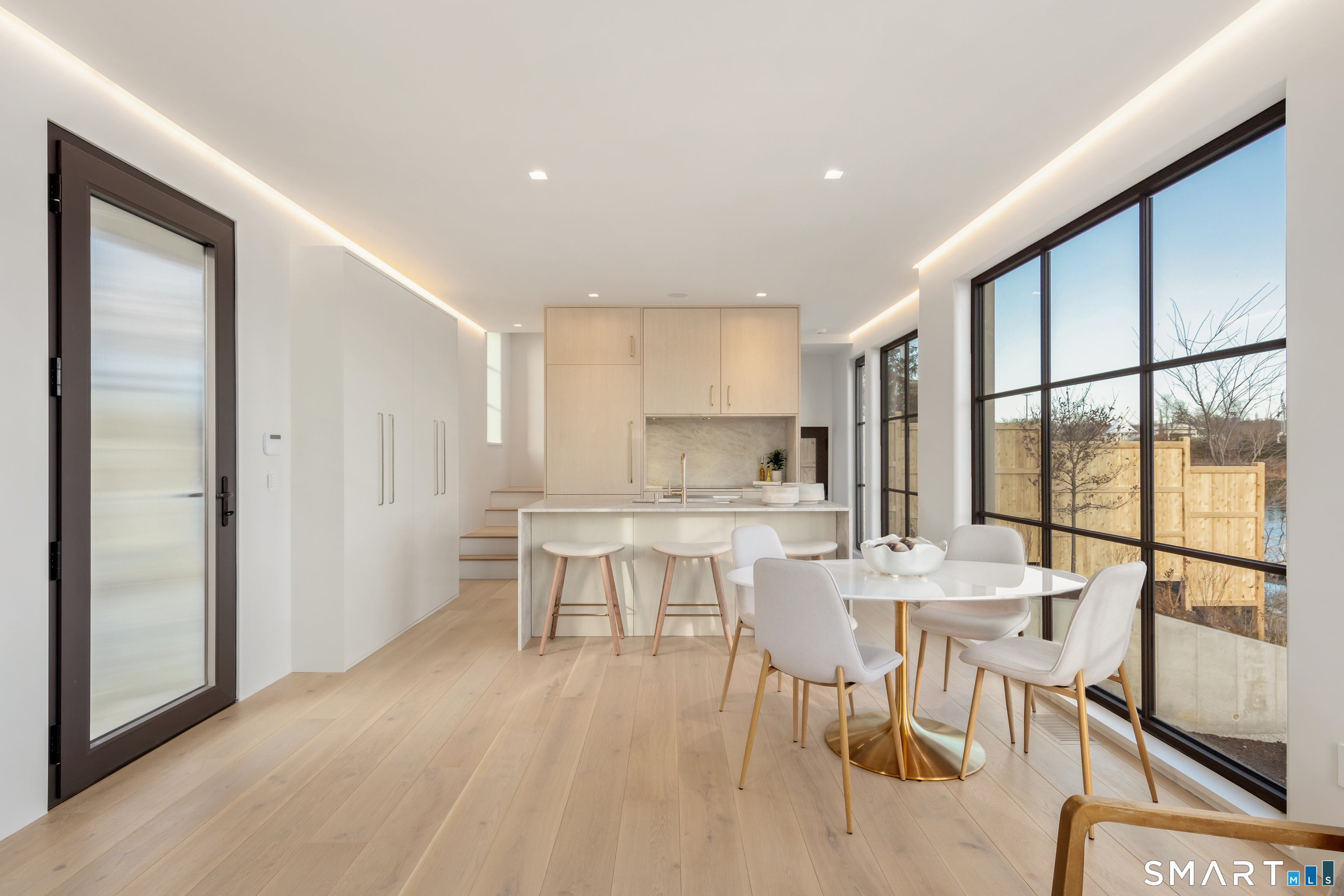 79 Riverside Avenue Westport, CT 06880 - Photo 5 of 40 a dining hall with stainless steel appliances granite countertop a stove a refrigerator a dining table and chairs with wooden floor