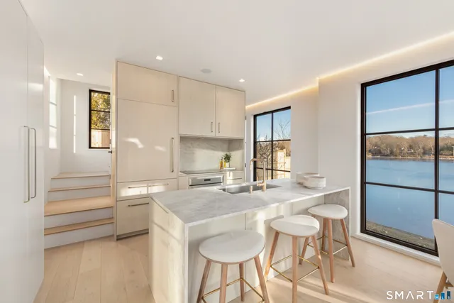 a kitchen with kitchen island a stove a table and chairs in it
