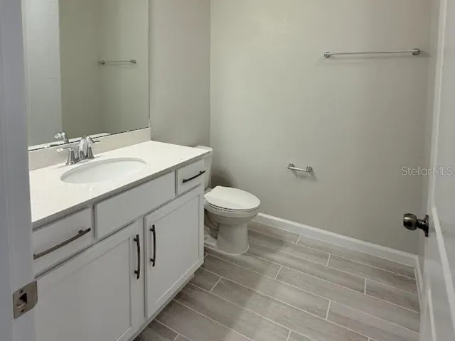a bathroom with a toilet a sink and mirror