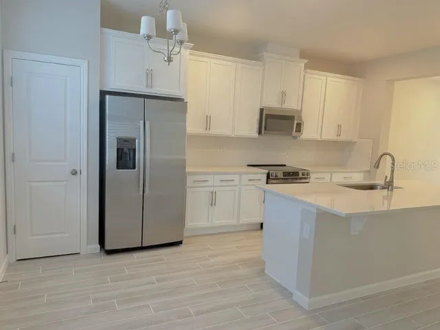 a view of a hallway with wooden floor and a bathroom