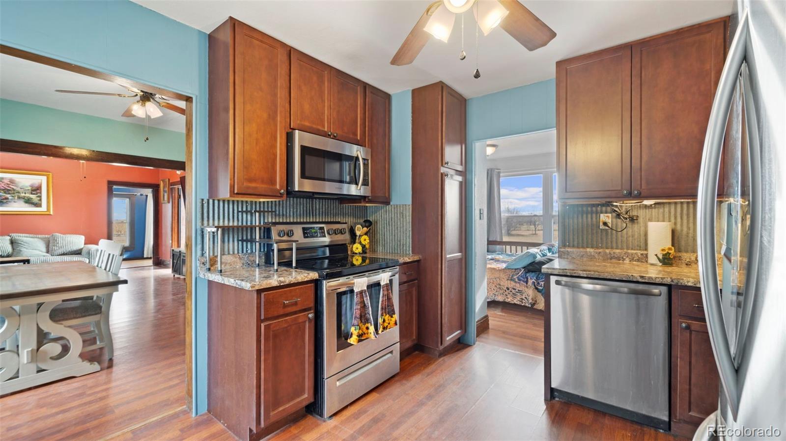 1935 County Road 75 Fleming, CO 80728 - Photo 15 of 50 a kitchen with stainless steel appliances granite countertop a stove top oven a sink dishwasher and cabinets with wooden floor